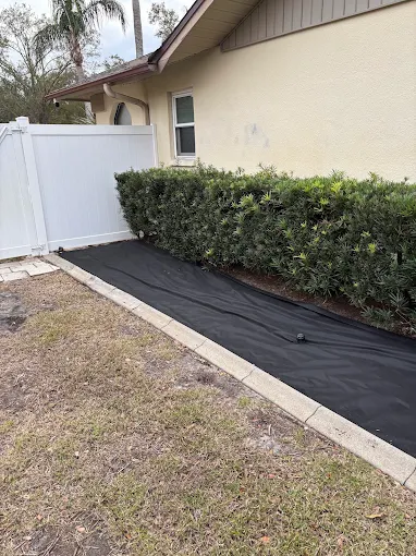 Landscape fabric laid along a hedge bed before rock install