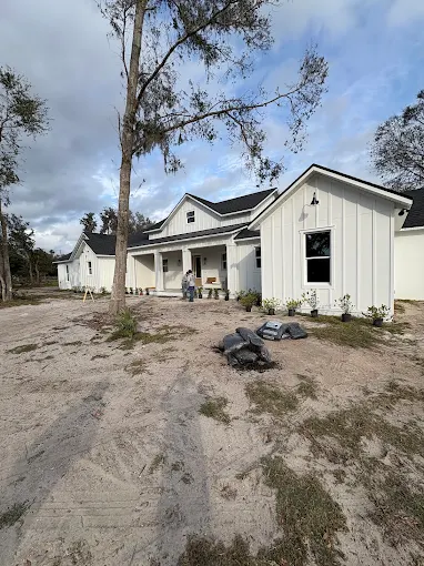 New construction farmhouse with graded yard prepped for sod